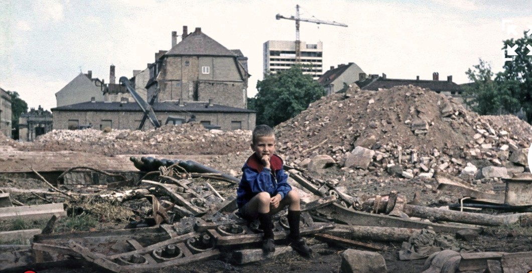 Ein Junge sitzt auf einem Trümmerhaufen der 1968 gesprengten Garnisonkirche, im Hintergrund entsteht das Interhotel